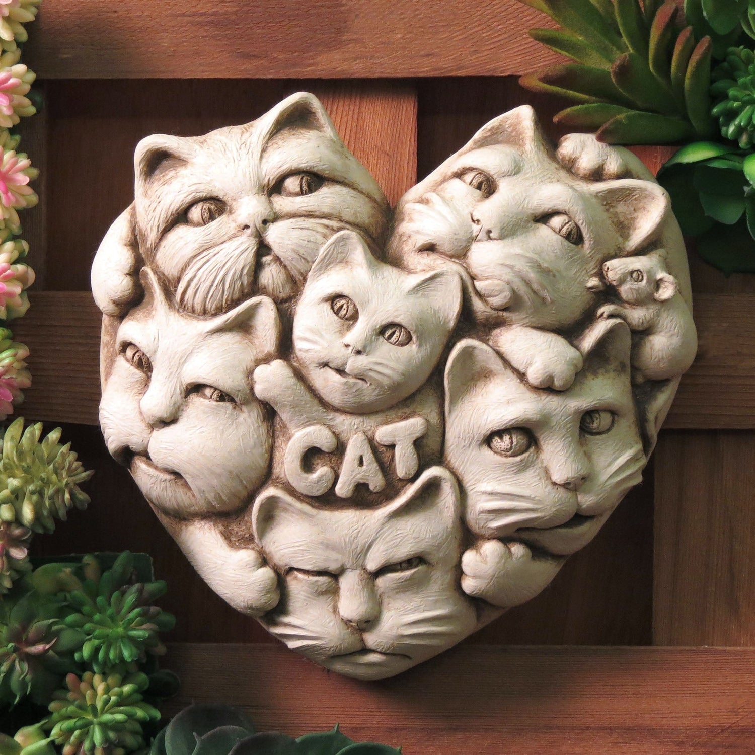Handcrafted stone sculpture of multiple cat faces arranged in a heart shape by Carruth Studio