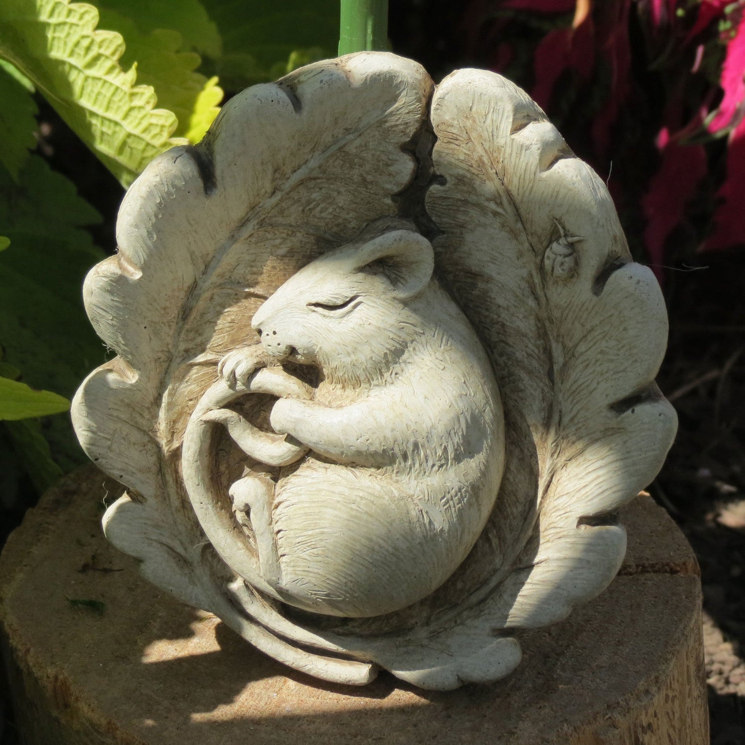 Handcrafted stone mouse sculpture sleeping in a bed of oak leaves by Carruth Studio